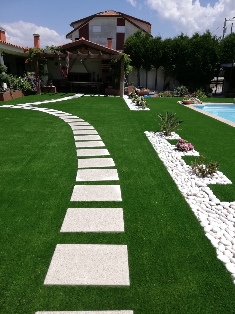 Jardim com relvado, caminho de lajes e piscina